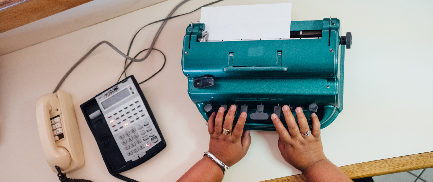 A person using a braille typewriter from above